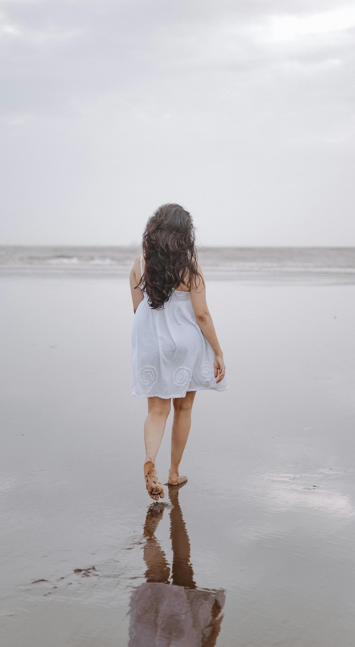 women stading on a beach from back image